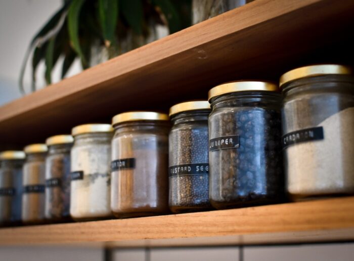 Store Cupboard Essentials for All Diets - shelf with spices and tinned food