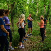 Clients with a movement coach in the woods at Combe Grove