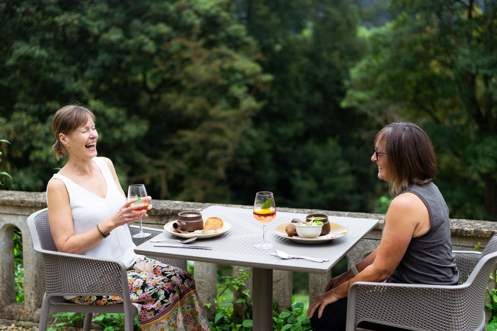 Two female clients having lunch outside at Combe Grove