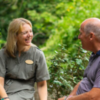 Dr Rebecca Hiscutt PhD talking with a client outside on the Combe Grove Estate.